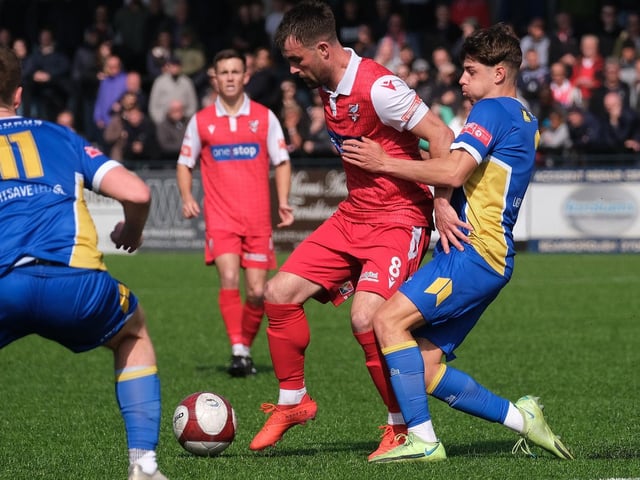 Midfielder Ryan Watson holds off a rival