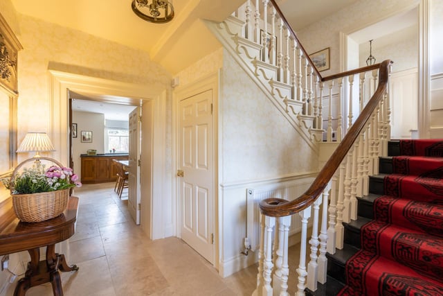 A spacious hallway with feature staircase.