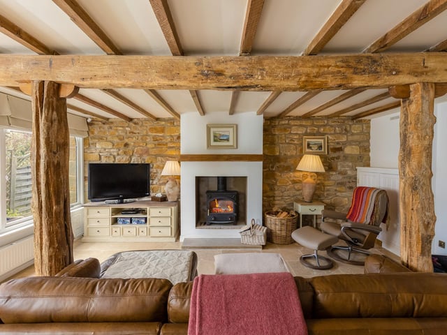 Beams, open stonework and a cosy stove create warmth and comfort within this lounge area.