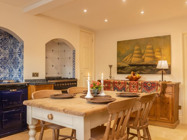 There is room for a sizeable table and chairs within this kitchen space, under spotlights.