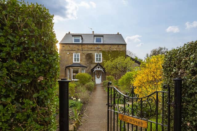 A stunning period home with pathway through gardens to the front door.