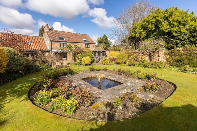 A water feature is central to this well established lawned garden.