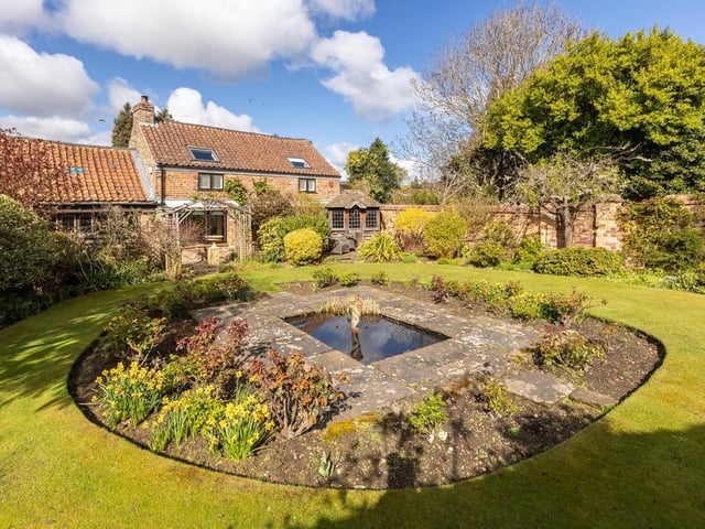 A water feature is central to this well established lawned garden.