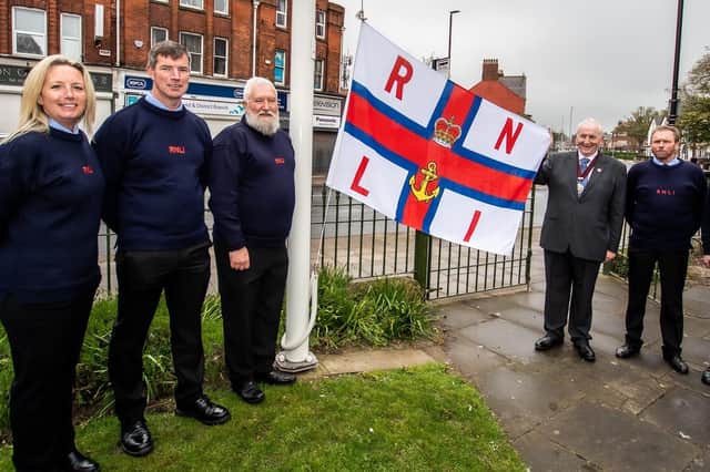 Mike Heslop-Mullens helps raise the RNLI flag for the MayDay Appeal. Photo courtesy of Mike Milner/RNLI