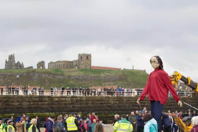Crowds line Whitby West Pier and the beach to see the giant Aura puppet.