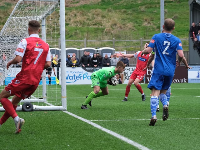 Warrington Town keeper Dan Atherton collects the ball as Boro winger Will Jarvis runs out of play