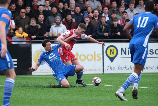 Warrington Town defender Matt Regan looks to nick the ball away ahead of Luca Colville