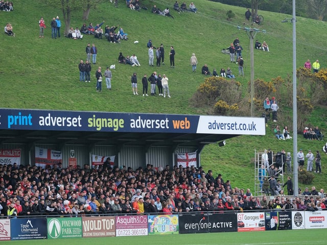 Boro fans watch from the fields behind the Flamingo Land Stadium