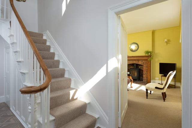 The entrance hallway with staircase featuring carved newel posts and a polished handrail.