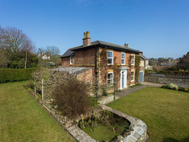 Lawned gardens and a large pond within the grounds.