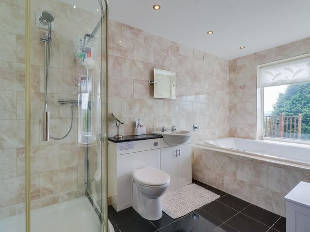 Bathe in comfort in this bathroom with a bath, corner shower cubicle and wash basin with vanity unit.