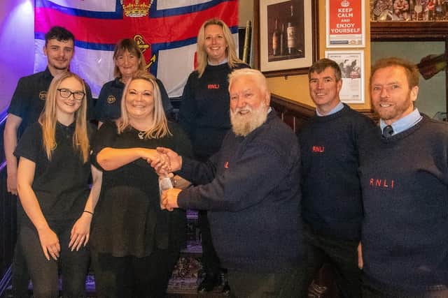 Bob Taylor and other RNLI members collect the cheque at Harbour Tavern. Photo courtesy of Mike Milner/RNLI