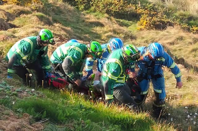 HART paramedics and Coastguard Rescue Officers move the casualty before before attaching him to the rope rescue system and hauling him up the cliff.