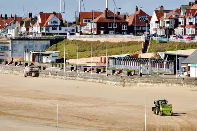 This photograph,taken by Aled Jones, shows the hard work needed to make the beach look pristine before visitors descend on the area.