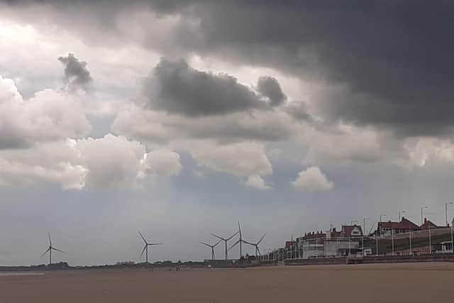 Sally Patchett frames the wind turbines towering above the south beach on a cloudy day.