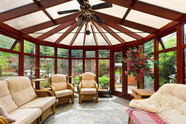 A spacious conservatory, surrounded by greenery.