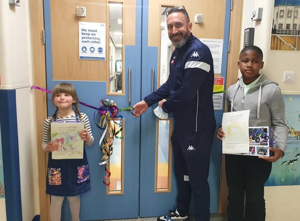 Children in the ward were invited to suggest a new name and draw a picture. Phoebe (age 6) and David (age 11) came up with the winning name - The Rainbow Ward. The youngsters are pictured with Scarborough Athletic manager Jonathan Greening as he cuts the ribbon to officially open the ward.