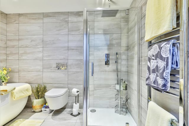 This modern bathroom includes a deep bath tub and a shower cubicle.