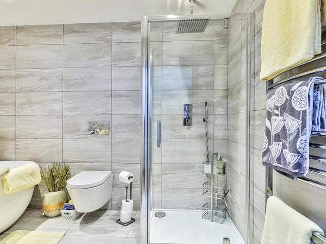 This modern bathroom includes a deep bath tub and a shower cubicle.