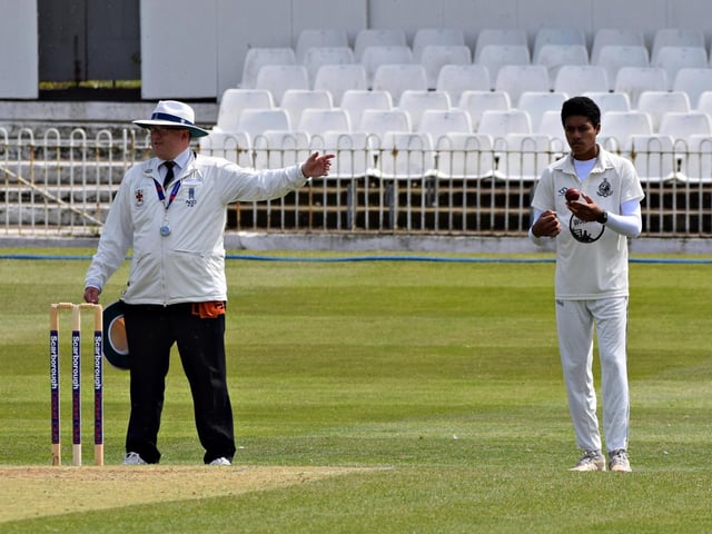 Scarborough 2nds spinner Josh Branch prepares to bowl alongside umpire Philip Robshaw