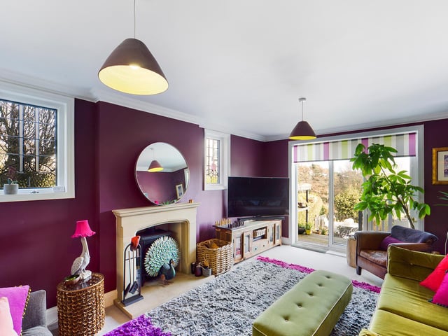 A central fireplace is a feature of this colourful lounge, with doors out to the garden.