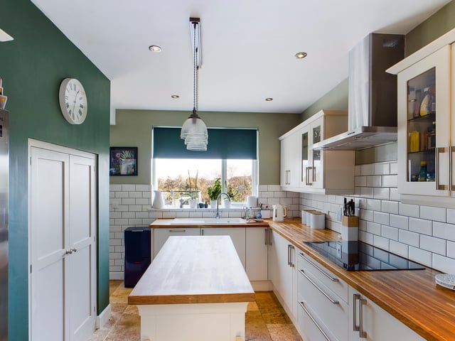 A central island provides further workspace and storage to the well equipped kitchen.