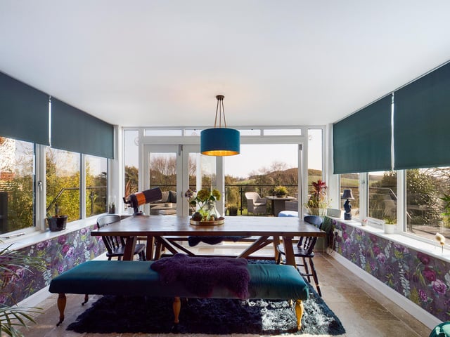 A lovely light room surrounded by greenery, in which to enjoy a meal.