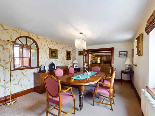An arched window adds interest to this room that has ample space for a large dining suite.