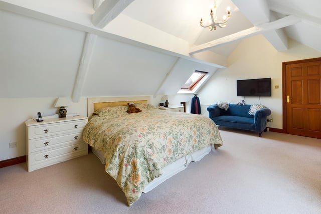 A vaulted ceiling and skylight window in this charming bedroom.