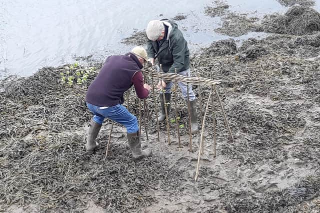 Lol Hodgson and Tim Osborne construct the Penny Hedge in Whitby harbour.
