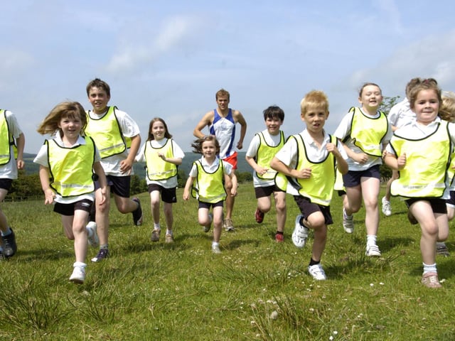 Children from Goathland Primary School run in the village with Alec Duffield from Loftus and Whitby Athletics Club.