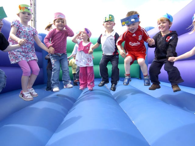 Young pupils from Oakridge Primary School enjoy their summer party on a bouncy castle.