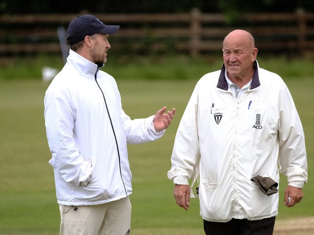The umpires confer in the game at Carr Lane