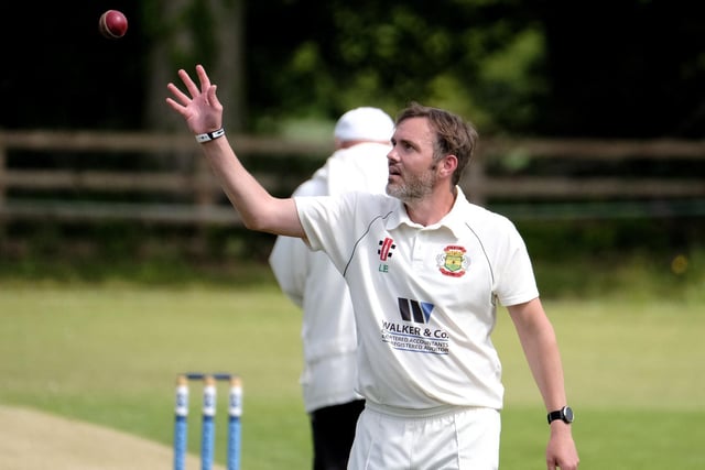 Folkton & Flixton 2nds bowler Peter Kay collects the ball before another delivery