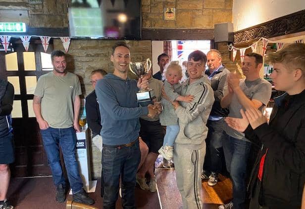 Julie and Mark Welford's son Robbie presents the Blacksmiths team with the trophy after veteran footballers raise £700 for British Heart Foundation in Mark & Julie Welford Memorial Trophy match.