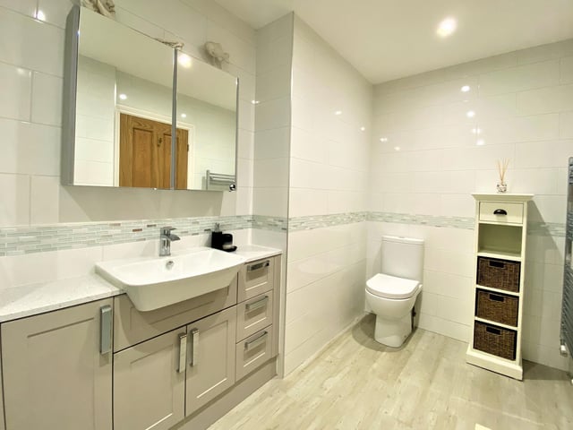 A built-in vanity unit is a feature of this apartment bathroom.