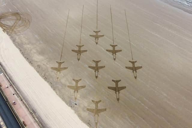 The Animated Objects Red Arrows sand art on South Bay beach.