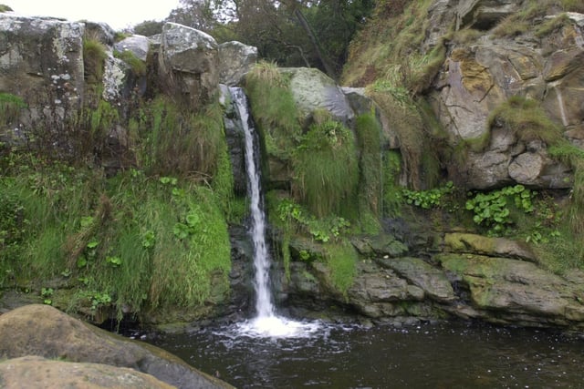 A coastal walk with waterfall at Hayburn Wyke, near Scarborough, where a stream cuts down through cliffs to tumble onto rocky beach below in a double waterfall.