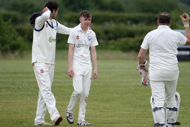 Jack Carradice-Clarkson of Flamborough is congratulated after dismissing Scarborough Rugby Club batter Paul Bond