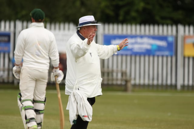The umpire signals a wide ball