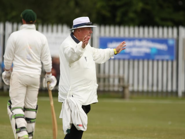 The umpire signals a wide ball
