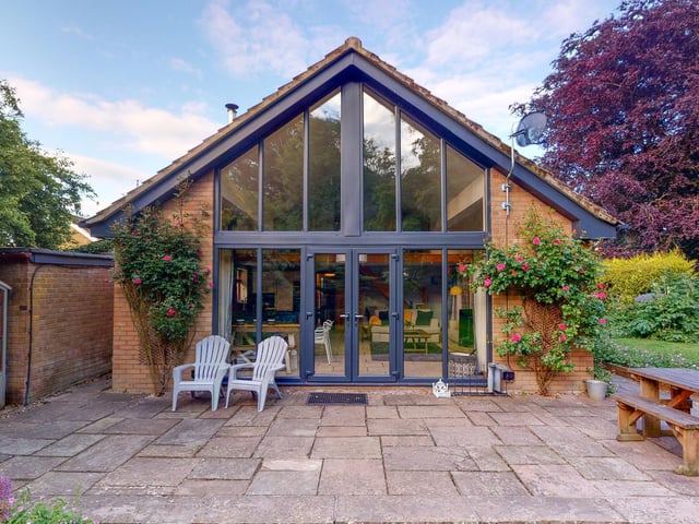 The virtual wall of windows fills the extended bungalow with natural light.