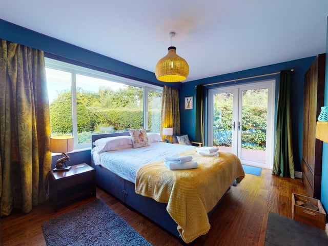 This lovely bedroom with a fireplace feature has doors leading outside.