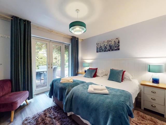 Another relaxing bedroom with doors leading outside.