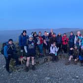 These walkers enjoy a spectacular mountain-top view of the sunset.