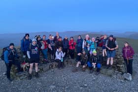 These walkers enjoy a spectacular mountain-top view of the sunset.