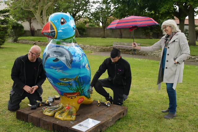 David Millington (left) and Liam Heads of Strata Holdings fix Coasty the Puffin into place at Cameron Gardens in Flamborough.