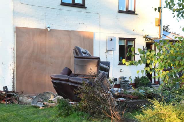 A large hole in the wall of the house was boarded up after the crash.