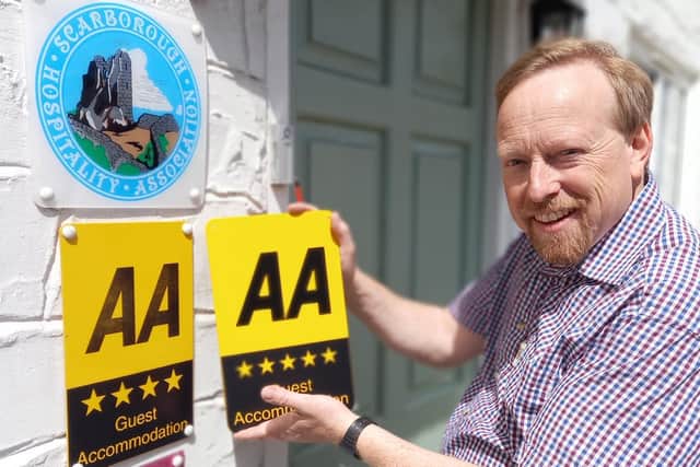 Andrew Jenkins installing new AA Five star signage at Orchard Lodge