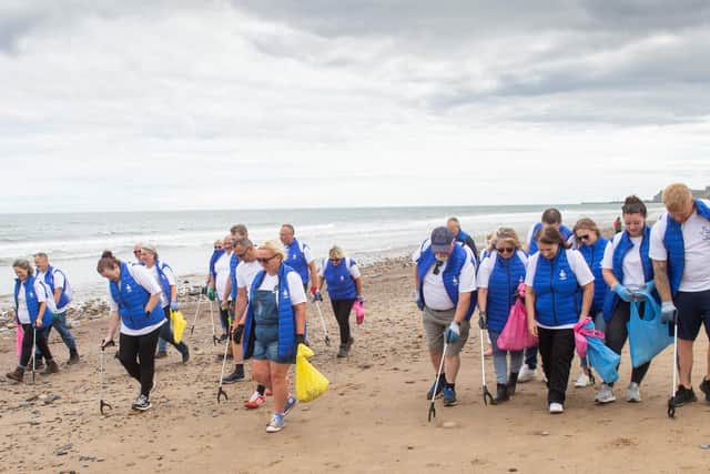 24 winners help collect litter during the sweep of the beach. Photo by Peter Powell.